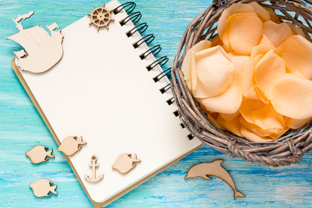flowers rose petals on turquoise wooden background, notebook, mockup, place for text,の写真素材