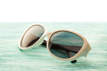 Stylish white sunglasses on the wooden background close up. horizontal  Stylish white  sunglasses on the wooden background close up. horizontal summer concept. the dismissal, blue background, holidayの写真素材