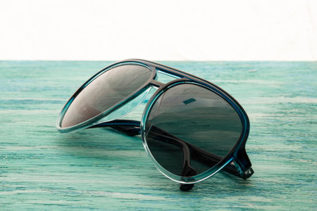 Stylish white sunglasses on the wooden background close up. horizontal  Stylish white  sunglasses on...