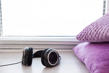 music background with dj headphones relaxing by the window. pillow, located on a stylized wooden sill. the concept of comfortの写真素材
