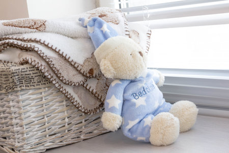 grey basket with children's toys, diapers, accessories on table on grey wooden background. Mother...