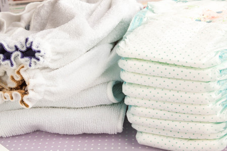 Modern eco stacks of cloth diapers and disposable diapers, pampers, close-upの写真素材