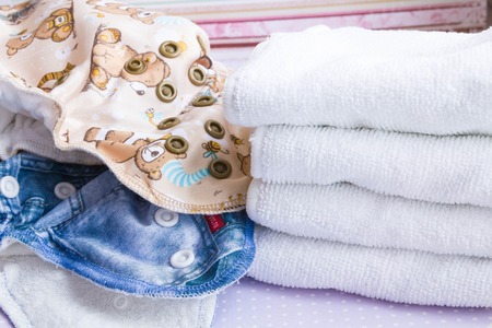 Modern eco stacks of cloth diapers and replacement bushings selective focus close-up on bright backgroundの写真素材