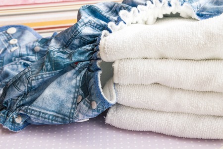 Modern eco stacks of cloth diapers and replacement bushings selective focus close-up on bright backgroundの写真素材