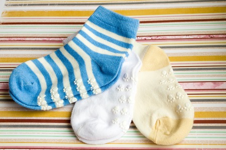 Kids bright background with three baby socks with copy space for Your messageの写真素材