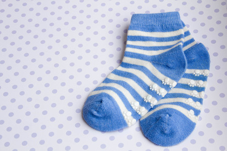 Baby blue background with baby socks with copy space for Your messageの写真素材