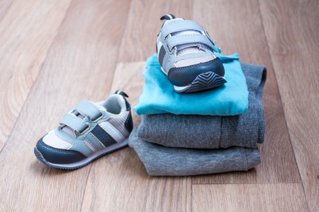 baby winter clothing, concept, autumn, sneakers, caps, toys. how to dress baby in winter choose shoesの写真素材