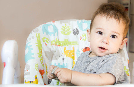 small happy child sitting in chair the concept of family, child health, feed the baby, eat at homeの写真素材