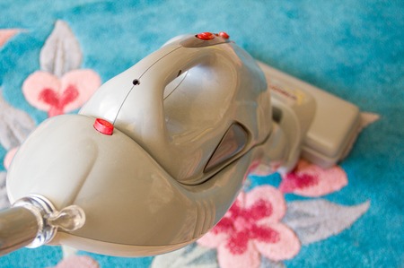 Close up of the head of a modern vacuum cleaner being used while vacuuming thick pile white carpetの写真素材
