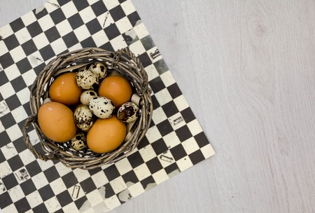 Plate with quail eggs and chicken eggs. Quail eggs in a wooden bowl. place for text. nutrition protein diet. Top view, flat lay with copyspace slogan or text message. colorful backgroundの写真素材