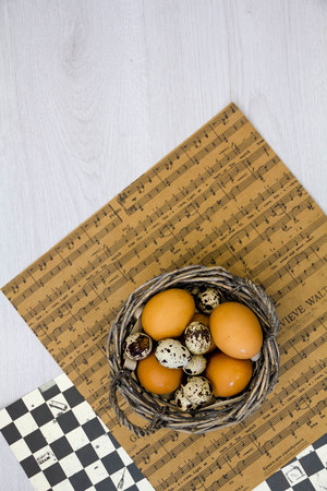 Plate with quail eggs and chicken eggs. Quail eggs in a wooden bowl. place for text. nutrition protein diet. Top view, flat lay with copyspace slogan or text message. colorful backgroundの写真素材
