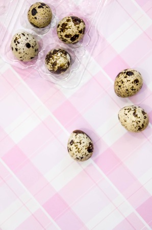 Plate with quail eggs and chicken eggs. Quail eggs in a wooden bowl. place for text. nutrition protein diet. Top view, flat lay with copyspace for slogan or text message. colorful backgroundの写真素材
