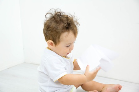 Adorable baby boy sitting on the floor, close upの写真素材