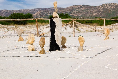 zen stone tower on the beach, with a sea wave splash around. Elongated stones in balance on seashoreの写真素材