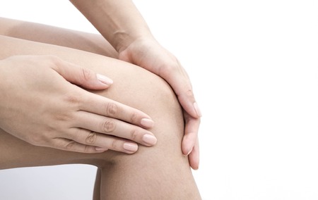 Woman having knee pain in medical officeの写真素材