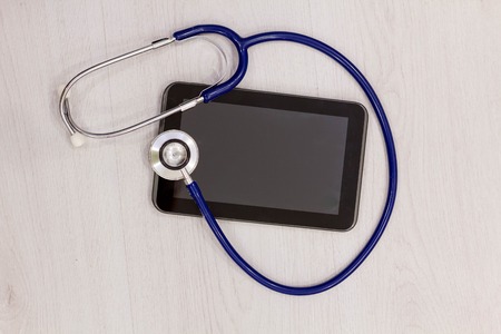 Medical tablet with screen empty screen on wooden tableの写真素材