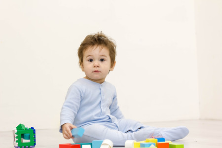 Adorable one year old child playing with toy cubes, isolated on whiteの写真素材