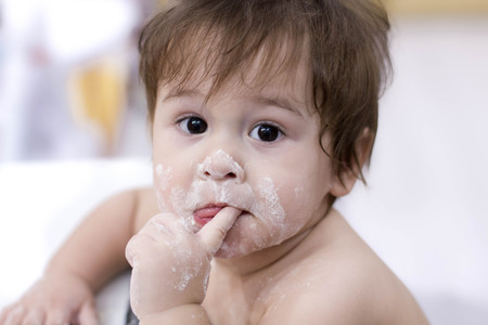 funny little dirty in flour helping her mom in the kitchen, than to take a child in one of the games in the kitchenの写真素材