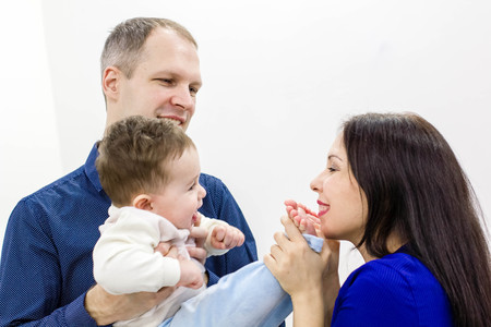 Smiling young parents and their child are very happy, they are at homeの写真素材