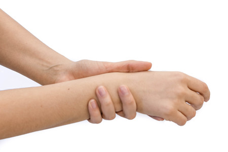 unhappy woman suffering from pain in hand at homeの写真素材