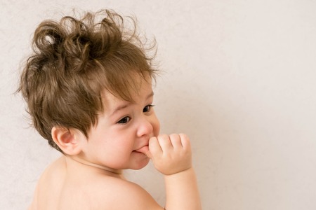 looking-back boy. Baby with one years old doing funny gestures. Beautiful smiling cute babyの写真素材
