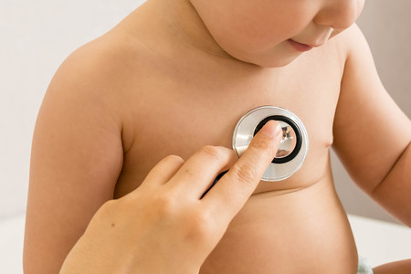 Baby at the doctor getting breath check up with stethoscopeの写真素材