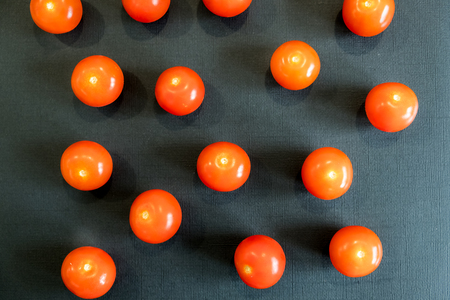 Fresh cherry tomatoes on black background. Top view with copy space.の写真素材