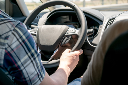 Drivers hands on the steering wheel inside of a carの写真素材