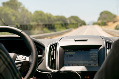 Drivers hands on the steering wheel inside of a car