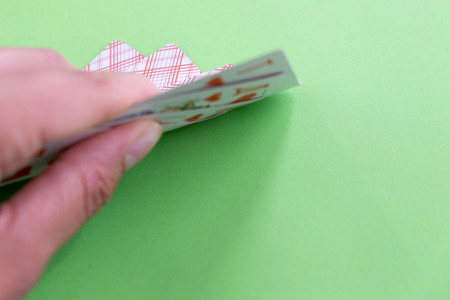 playing cards in a people hand. Close-up of a poker player holding playing cardsの写真素材