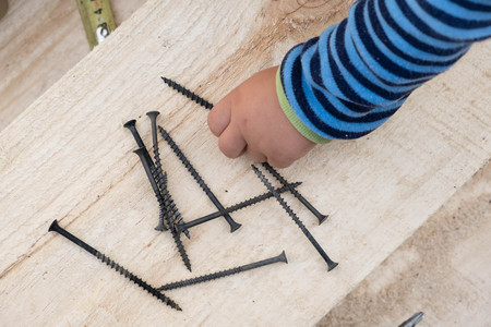 little boy in an orange helmet and toolsの写真素材