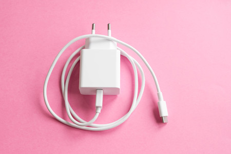 Charger for smartphone or tablet on pink background.の写真素材