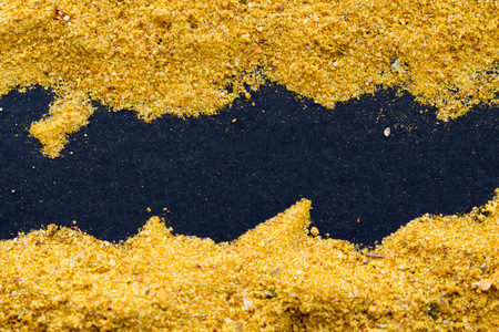 heap of curry powder on black slate backgroundの写真素材