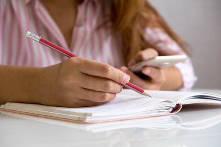 Business woman working at office with laptop and documents,rear view of young business woman hands busy using holding documents,Open space loft office reading sitting at the desk on officeの写真素材