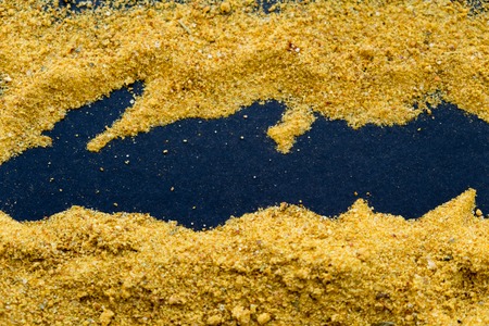 heap of curry powder on black slate backgroundの写真素材