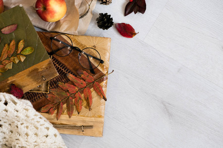 Fresh Pastry Bun, Cup of hot coffee and autumn leaves on wooden background. Wooden letters word AUTUMN. Top view, copy space.の写真素材