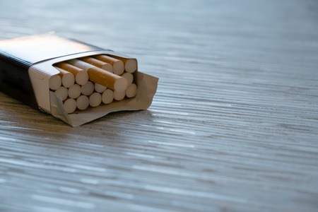 open cigarettes in pack and tobacco , close up. STOP Smoking. World no tobacco day. Cigarette with brown filter in the box with ash. copy space,の写真素材