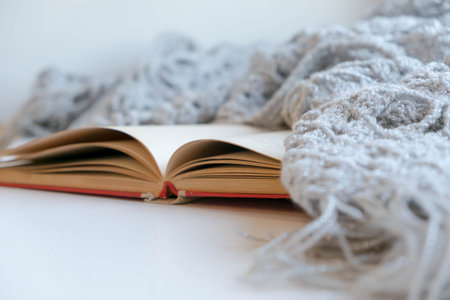 Cozy winter still life: opened book. Warm and comfy autumn or winter concept. sweater. Reading...
