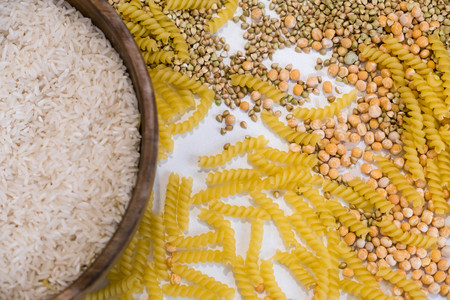 Set of products with complex carbohydrates on white background. wooden spoon, a range of cereals, pasta. Gluten free flour and cereals millet, green buckwheat, basmati rice,up viewの写真素材