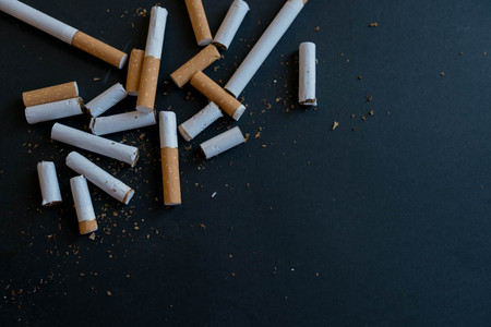broken scattered cigarettes, tobacco, close-up on a black background. Top view with copy space, flat lay. STOP Smoking. World no tobacco day.の写真素材