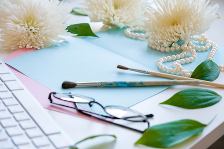 Notes of creative worker scattered on table. Work place of a creative person with a variety of colorful stationery objects. Business concept with copy space. Office desk table with glasses focusの写真素材