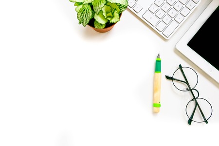 Modern white office desk table with laptop computer, Stylish tablet with black screen over a notebook and cup of coffee, glasses. Top view with copy space, flat lay. workspace creative designer.の写真素材