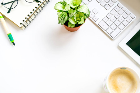Modern white office desk table with laptop computer, Stylish tablet with black screen over a notebook and cup of coffee, glasses. Top view with copy space, flat lay. workspace creative designer.の写真素材