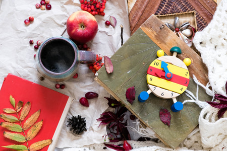 Fall Time Alarm clock on a rustic wooden table with colorful Autumn leaves. with light shadow and shallow depth of field. Daylight savings time concept. Autumn Time Change, with copy space. Top viewの写真素材