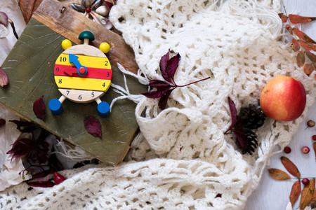Fall Time Alarm clock on a rustic wooden table with colorful Autumn leaves. with light shadow and shallow depth of field. Daylight savings time concept. Autumn Time Change, with copy space. Top viewの写真素材
