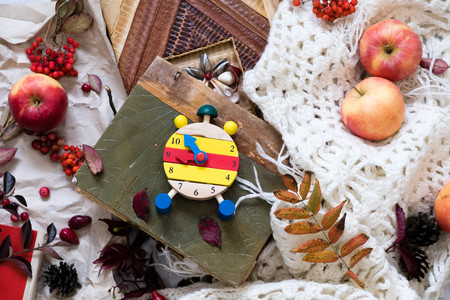 Fall Time Alarm clock on a rustic wooden table with colorful Autumn leaves. with light shadow and shallow depth of field. Daylight savings time concept. Autumn Time Change, with copy space. Top viewの写真素材