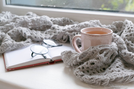 Mug of black coffee wrapped in warm scarf on wooden board. Top view, vintage style, Still life.の写真素材