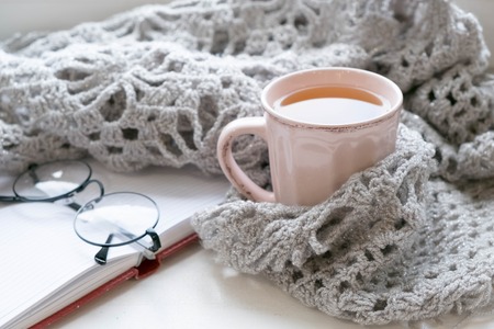Mug of black coffee wrapped in warm scarf on wooden board. Top view, vintage style, Still life.の写真素材