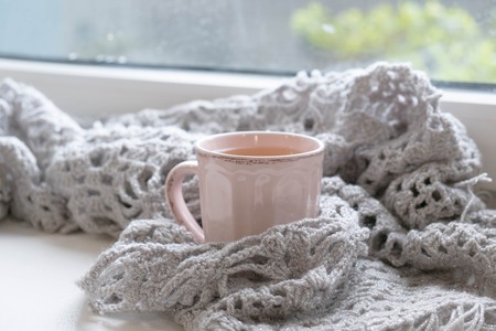 Mug of black coffee wrapped in warm scarf on wooden board. Top view, vintage style, Still life.の写真素材