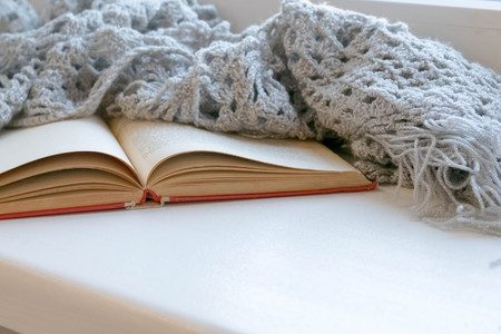 Cozy winter still life: opened book. Warm and comfy autumn or winter concept. sweater. Reading relaxing cold fall weather at home. Winter holidays, Christmas time concept, free copy spaceの写真素材
